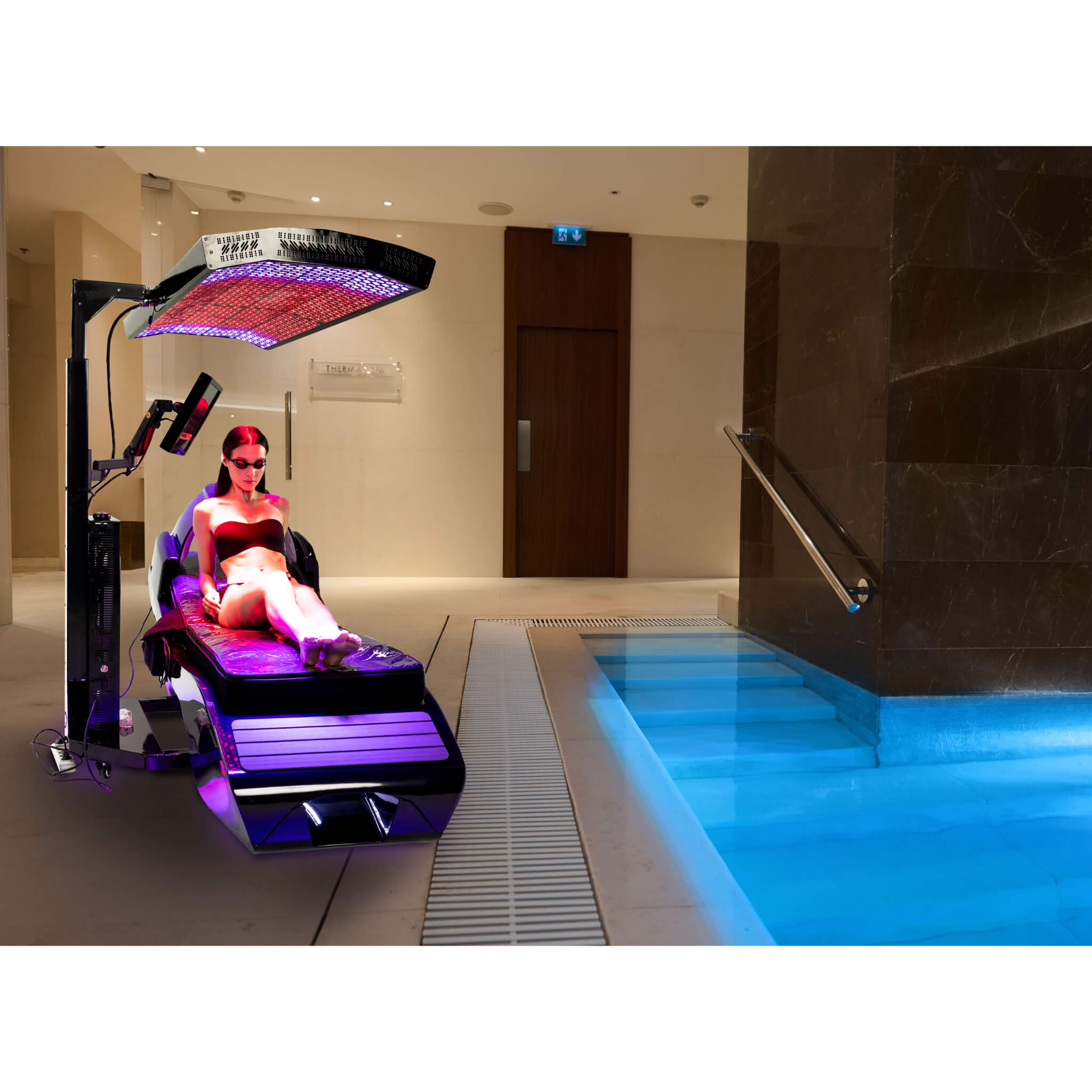 Cryonick InfraCouch Red Light Therapy Bed, woman siting with top panel lights on near a pool