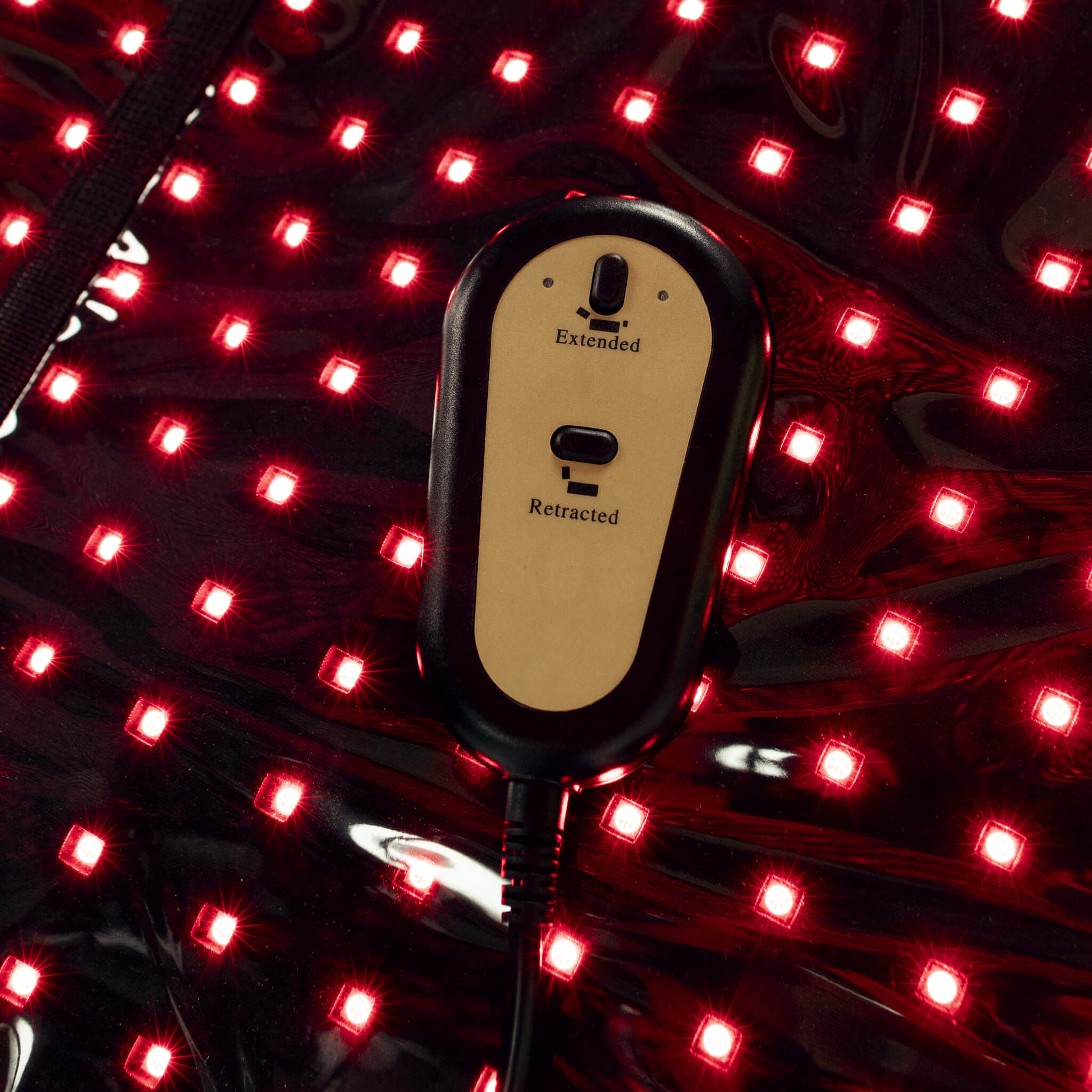 Cryonick InfraCouch Red Light Therapy Bed with red LED lights on and a controller