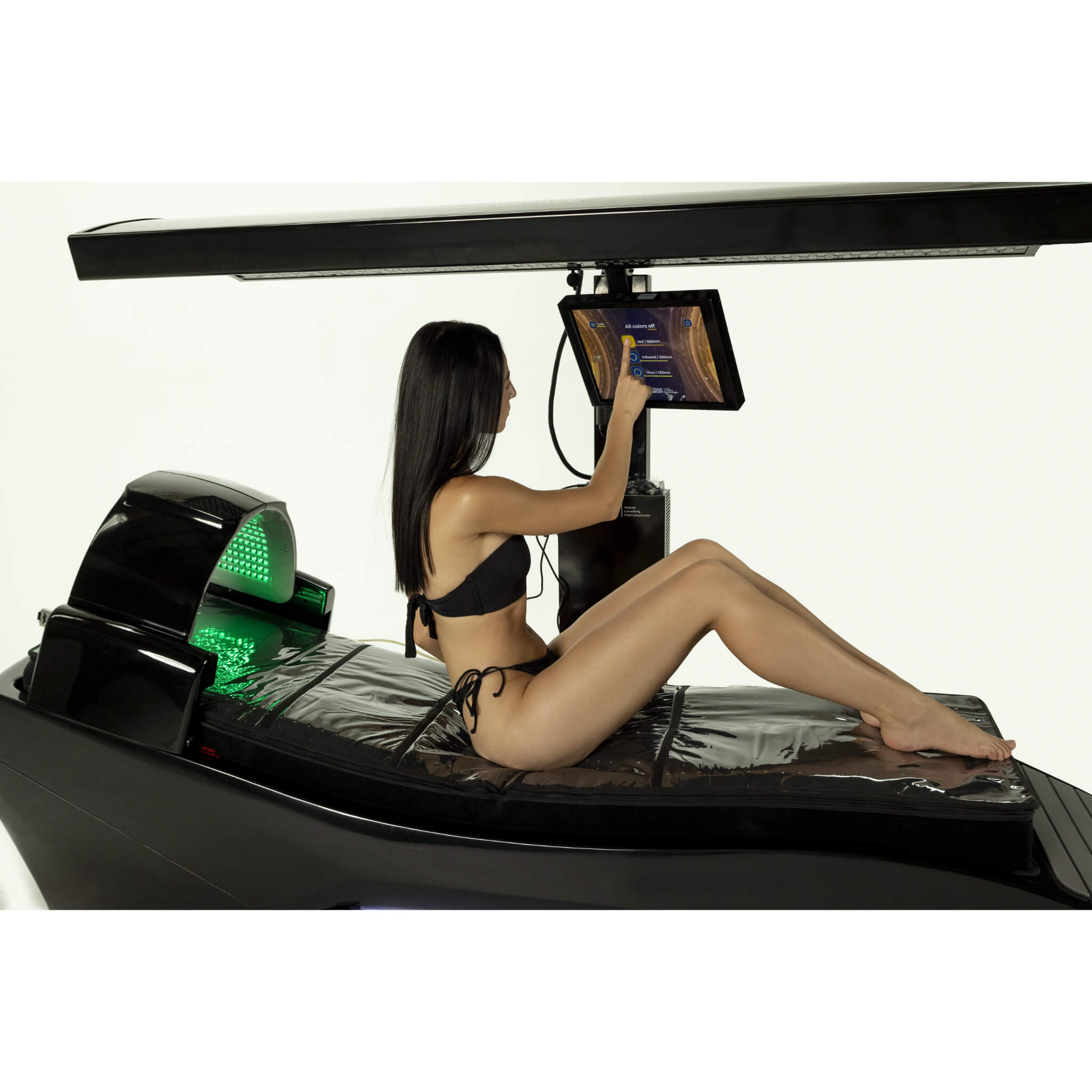 Cryonick InfraCouch Red Light Therapy Bed, woman sitting and using the control panel.