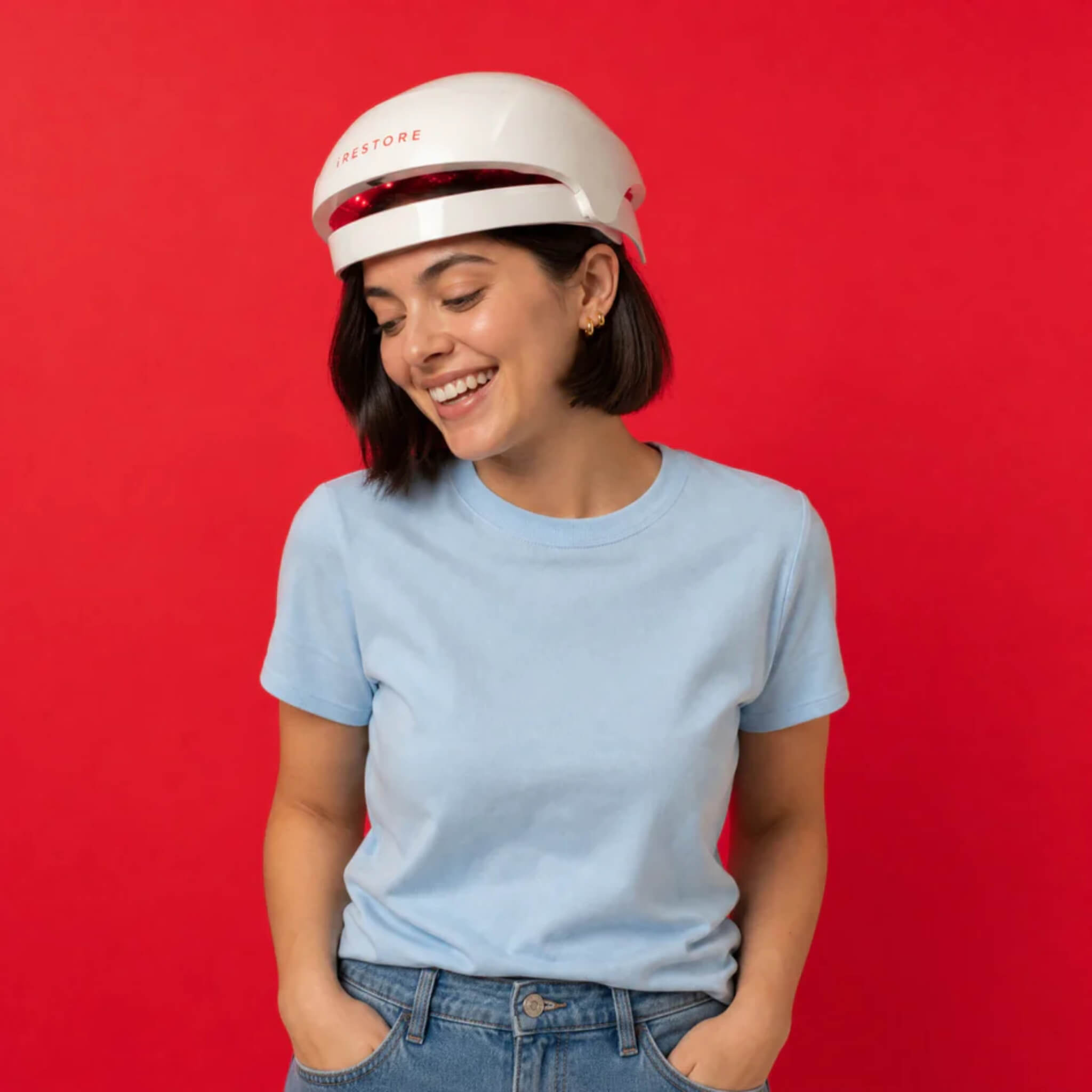iRESTORE Essential laser hair growth cap worn by woman in light blue shirt