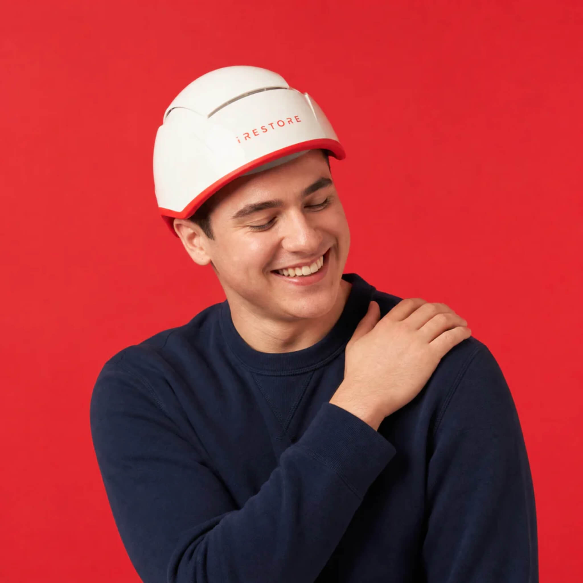 iRESTORE Professional laser hair growth cap worn by man in navy sweater