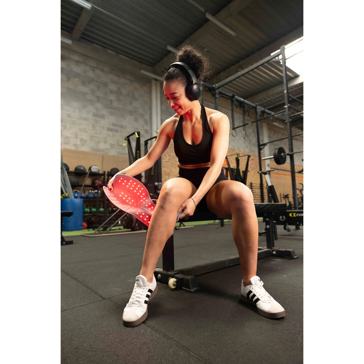 Woman at the gym putting on the NovaaLab Novaa Knee Ultra after a workout