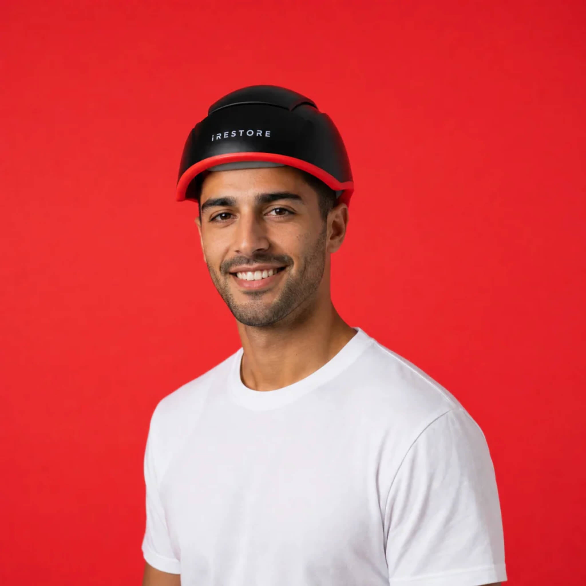 Young man wearing iRESTORE Elite laser hair growth helmet showing comfortable fit and full scalp coverage