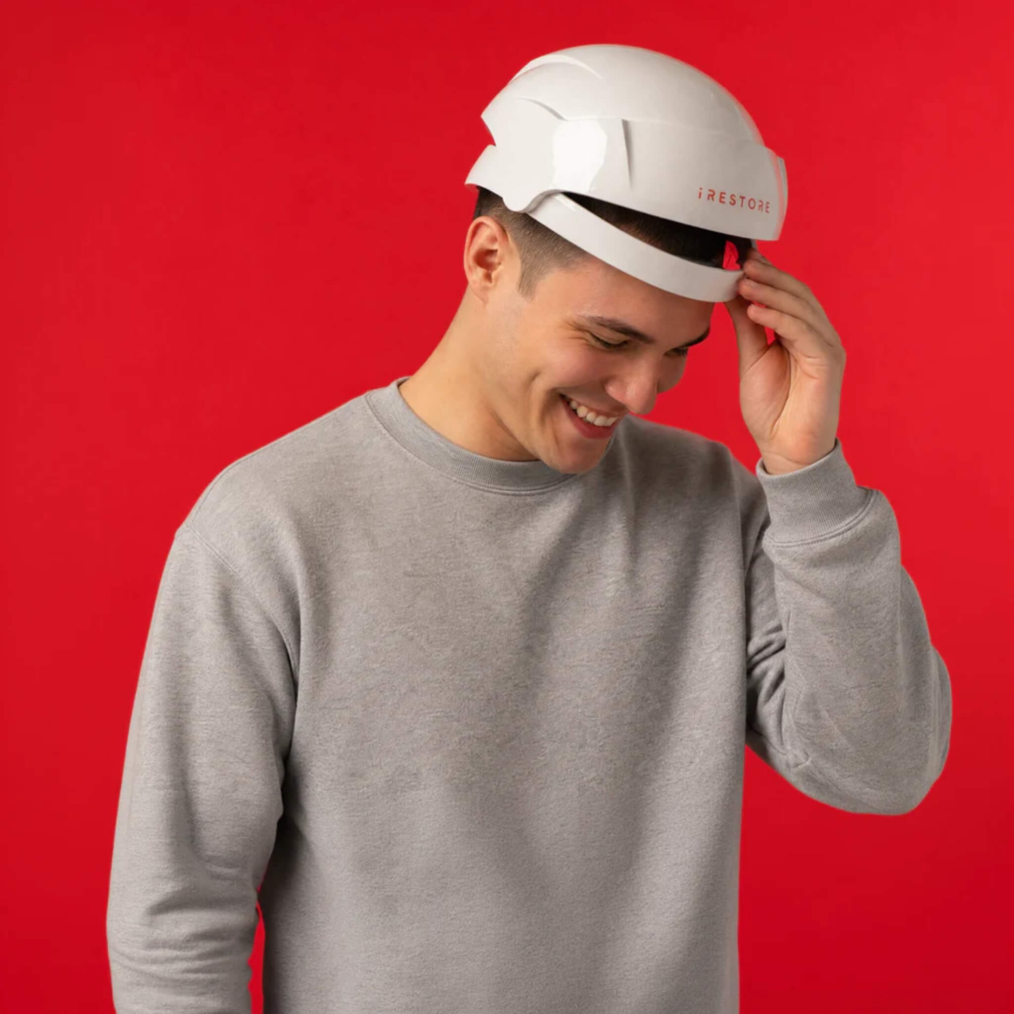 Man wearing iRESTORE Essential hair growth cap in gray sweater