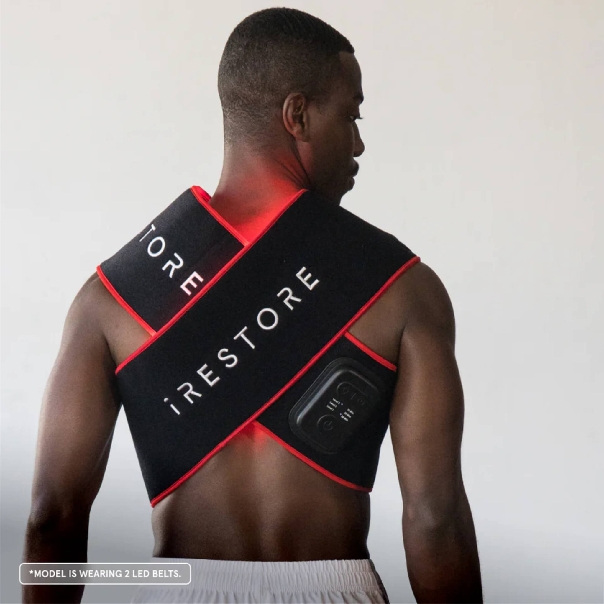 Man wearing two iRESTORE Flex LED Belts crossed over his back and shoulders