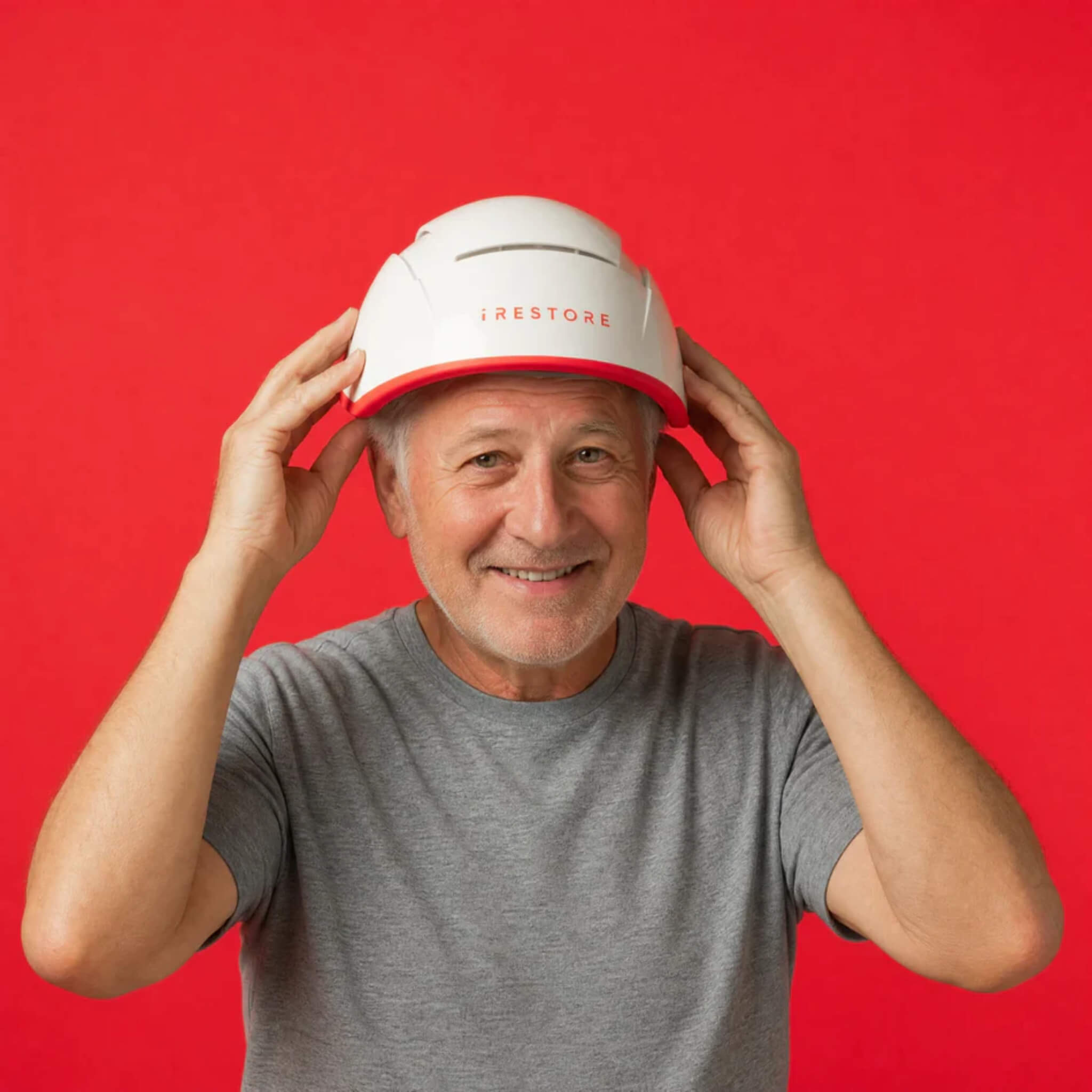 Mature man putting on iRESTORE Professional laser hair growth cap