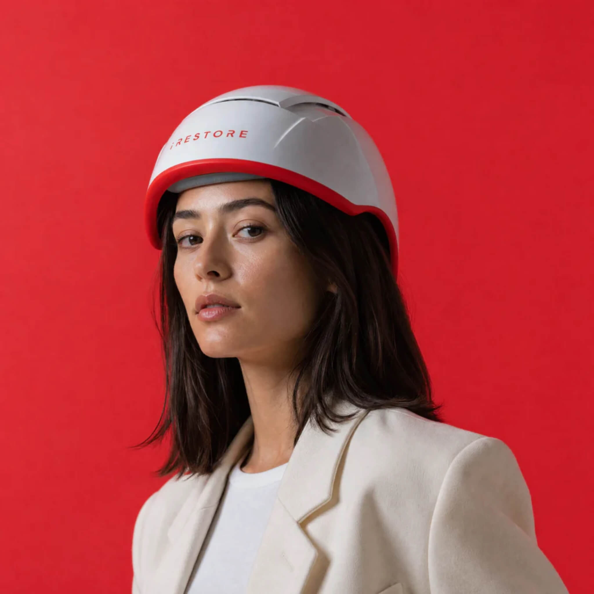 Woman wearing iRESTORE Professional laser hair growth cap in beige blazer