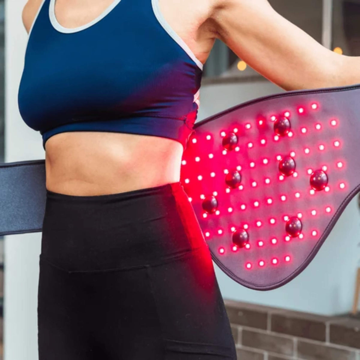 Close view of the NovaaLab Novaa Back Pad red LEDs and vibration points being wrapped around the waist