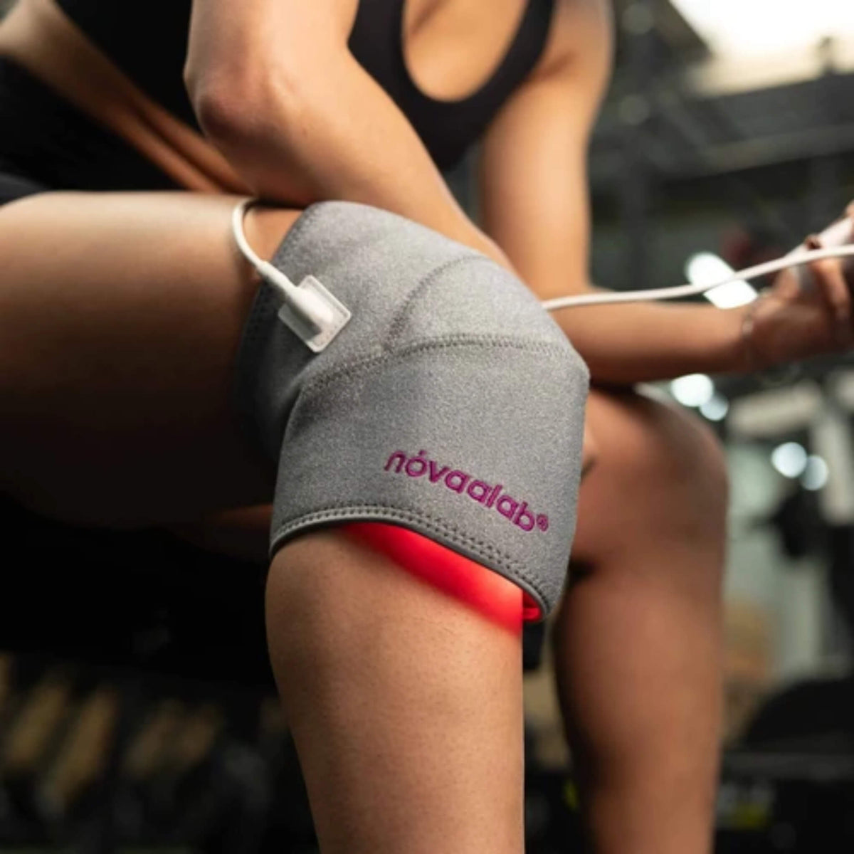 NovaaLab Novaa Knee Ultra wrapped around the knee with red light glowing underneath