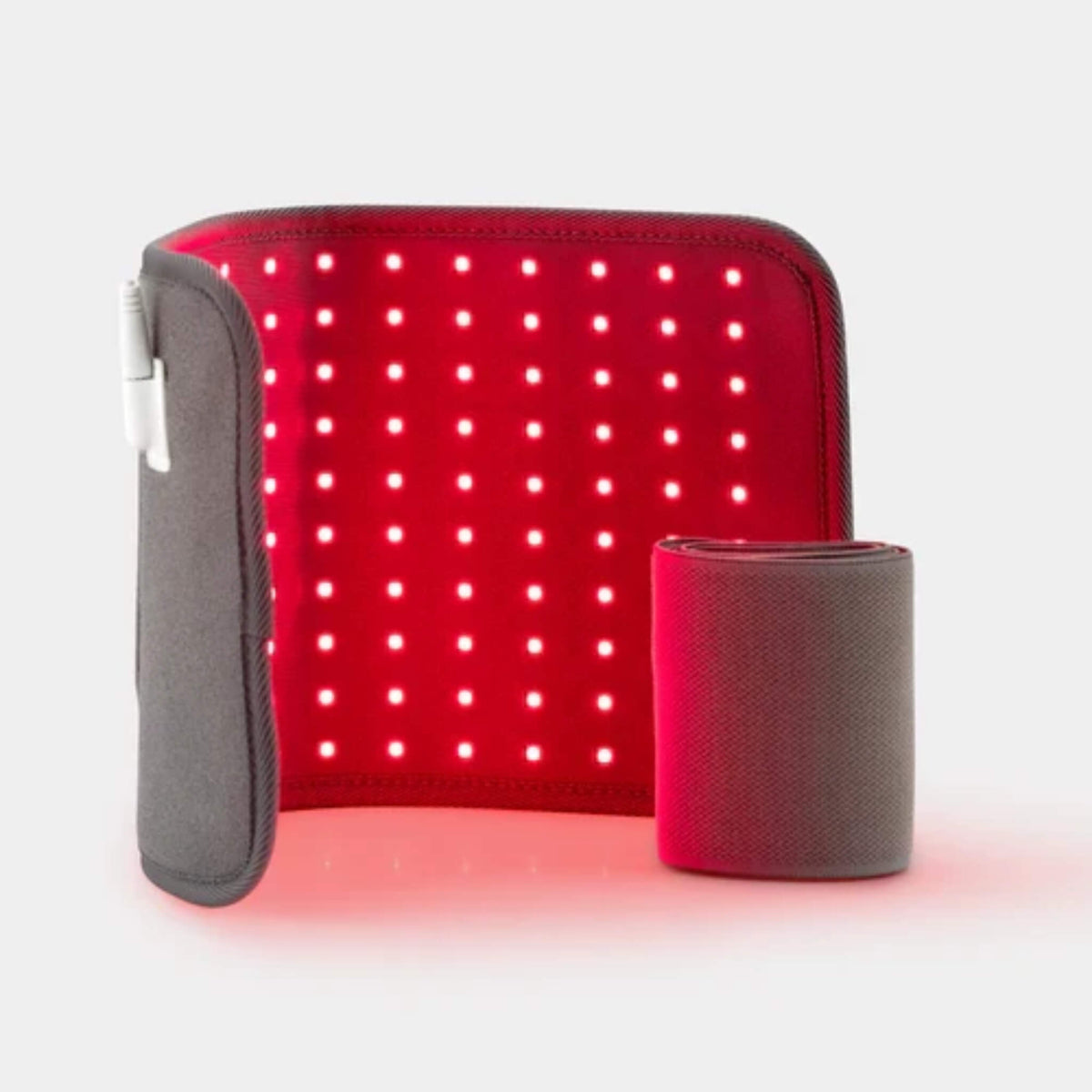 NovaaLab Novaa Light Pad curved with its red LEDs lit next to the rolled stretchy strap